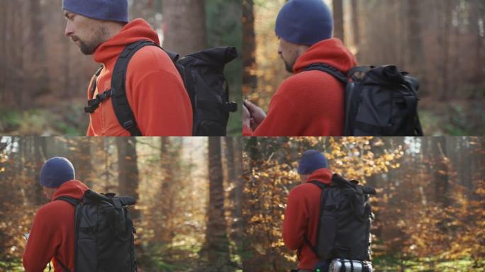 徒步旅行时在户外地图。徒步旅行者使用智能手机通过应用制图在森林中导航。通过智能手机徒步旅行路线。旅行