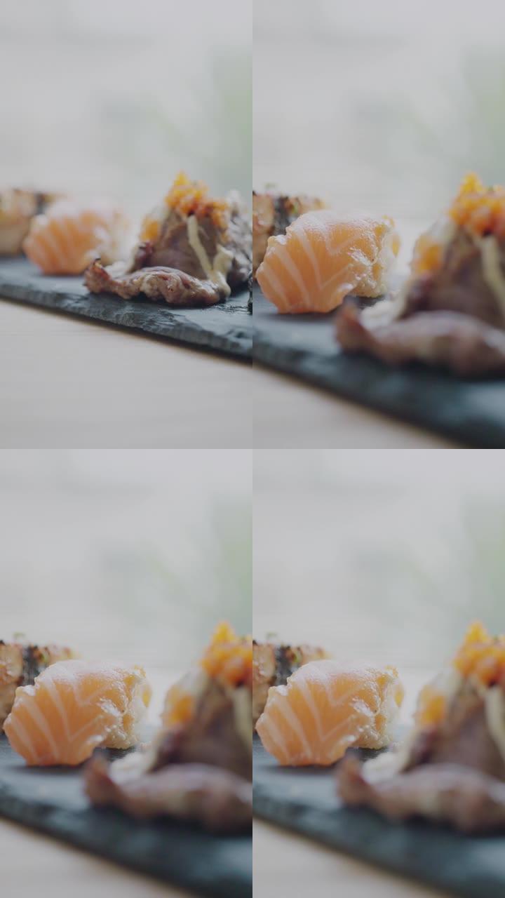 日本料理的概念。在时尚的木制桌子上的日本餐厅里的一盘寿司卷。