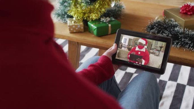 白化病男子挥舞并使用平板电脑与屏幕上的圣诞老人进行圣诞节视频通话
