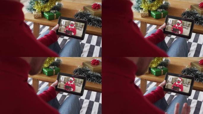 白化病男子挥舞并使用平板电脑与屏幕上的圣诞老人进行圣诞节视频通话