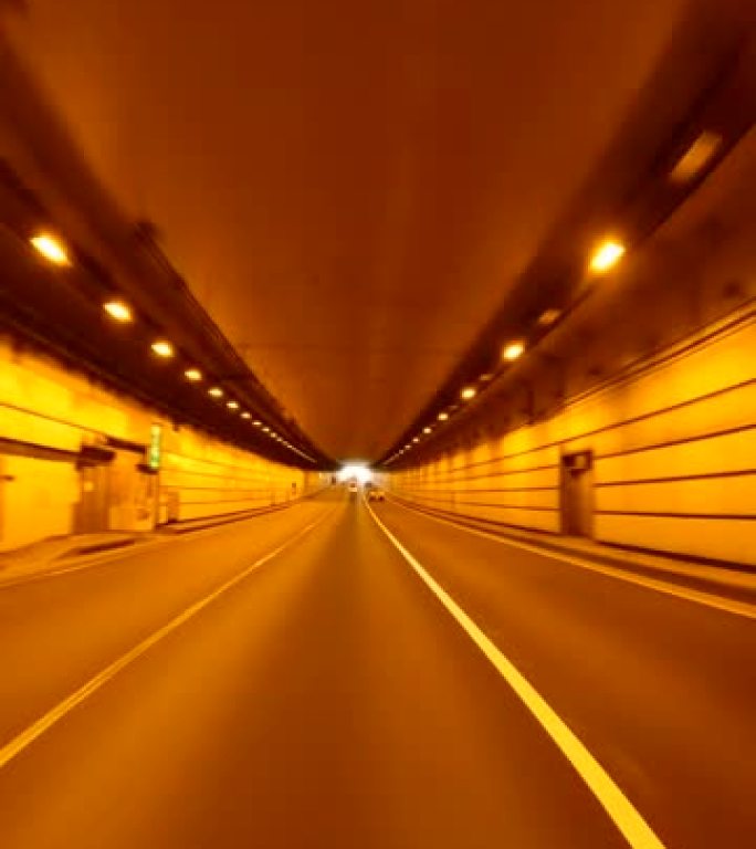 开车穿过高速公路隧道。高速公路隧道出口。隧道尽头的光
