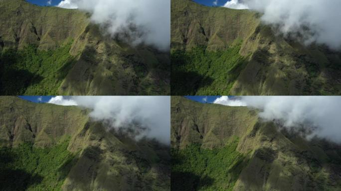 从上方可以看到，令人惊叹的鸟瞰图是绿色的山脉，周围环绕着云层，背景是美丽的蓝天。印度尼西亚西努沙登加