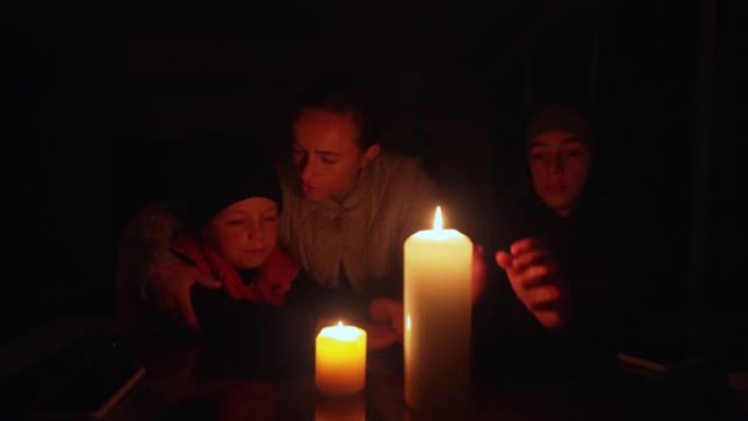 停电期间，家人坐在蜡烛旁。乌克兰战争
