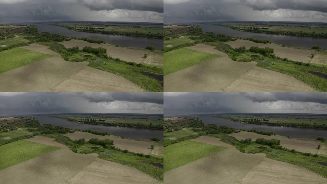 中午的无人机摄影左图——明亮的农田和田野，宽阔的河流和乌云在背景中。波美拉尼亚，波兰，欧洲