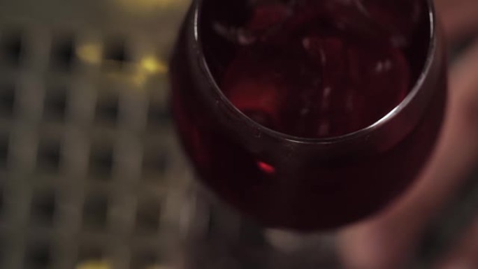 俯视图混合一个红色的鸡尾酒与一片柠檬和冰块