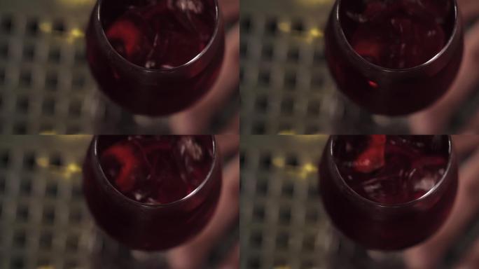 俯视图混合一个红色的鸡尾酒与一片柠檬和冰块