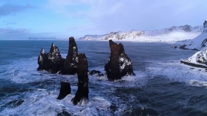 雷尼斯法加拉黑沙滩上尖锐悬崖的鸟瞰图，海浪冲击海岸。冰岛的维克镇