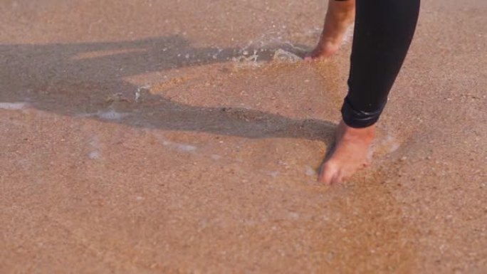 无忧无虑的印度女性在海滩上泼水的腿的特写镜头。暑假在热带海滩玩耍的女人。休闲活动