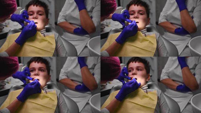 一位女儿科牙医在牙科诊所给她的孩子麻醉的特写镜头。