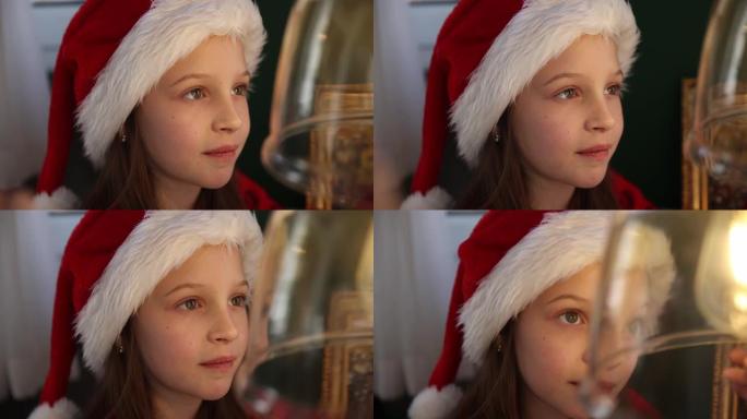穿着圣诞服装的高加索小女孩在家里度过圣诞节，看着一站复古灯泡