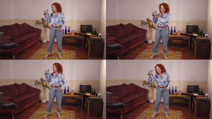 快乐自信的天才复古女人站在家里的老式相机上录制。快乐高加索红发女郎在20世纪80年代20世纪70年代