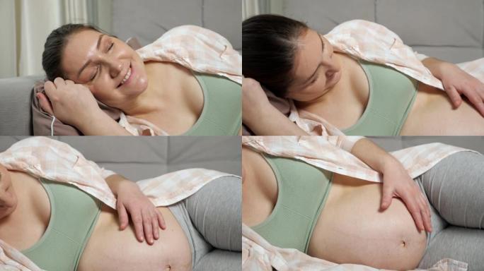 孕妇躺在沙发靠垫上抚摸着肚子微笑