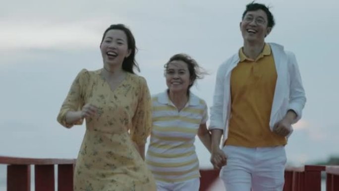 亚洲家庭在桥上奔跑，去观光点看日落。