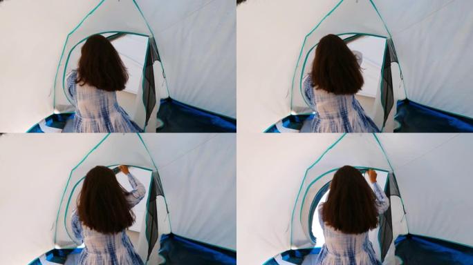 美丽的印度女人的后视图与开放的头发在海滩野营帐篷开链。露营帐篷度假和年轻女子享受自由的海滩-旅游旅游