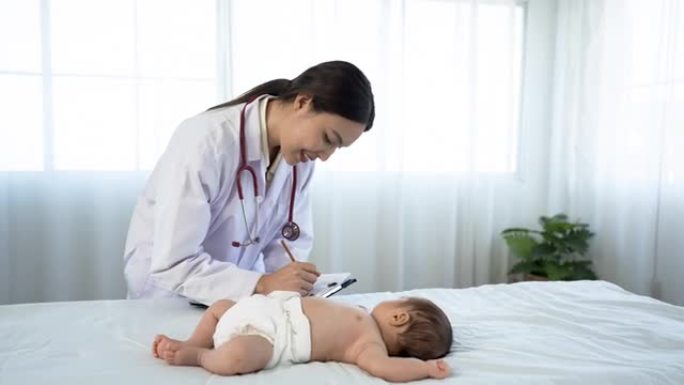 亚洲妇女谁是儿科医生健康检查生病的新生儿婴儿躺在医院检查室的白色床上