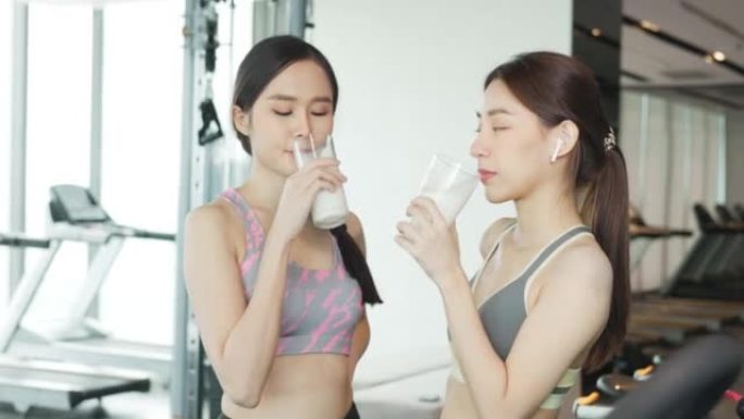 迷人的健身亚洲妇女完成锻炼和喝蛋白质牛奶奶昔维生素训练后。健美。健康的生活方式。