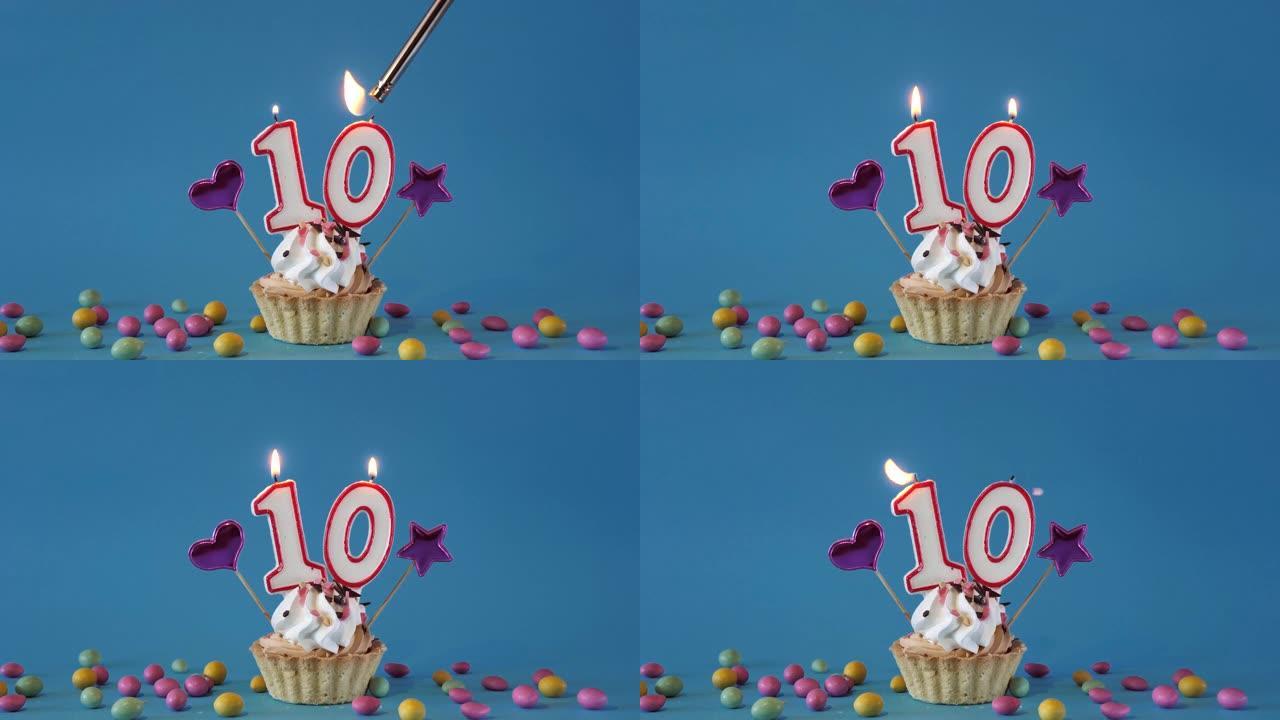 给一个10岁的孩子生日快乐，一个带有蜡烛的生日蛋糕和蓝色背景上的生日装饰品。点燃并熄灭纸杯蛋糕上的节