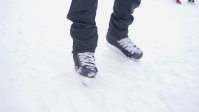 黑色溜冰鞋的特写镜头。滑冰。溜冰场。在冰雪上滚动