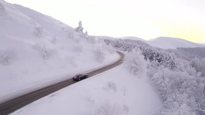 冬季在通往山区的道路上追逐黑色汽车