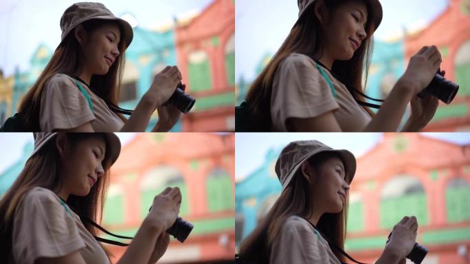 亚洲年轻女性背包客用相机到摄影的地方旅行时带着快乐的情感表达，在生活方式假期夏天独自旅行。