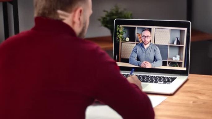 商务男性与同事在线视频通话远程会议使用笔记本电脑在家工作
