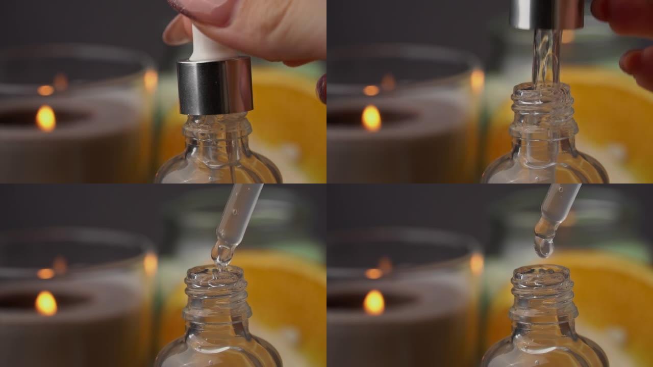 精油从吸管滴入蜡烛背景下的瓶子中