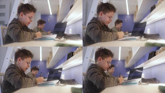 十几岁的男孩在他们的房间里做作业。