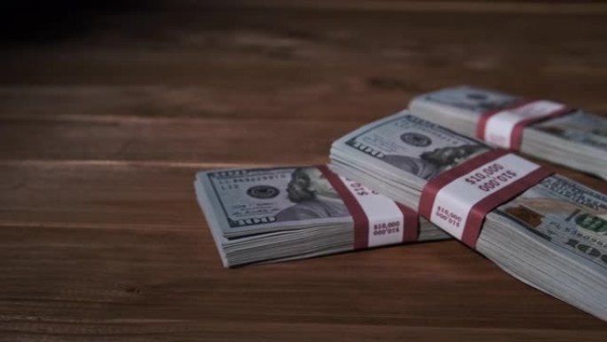三叠成束的10000美元钞票躺在木桌上