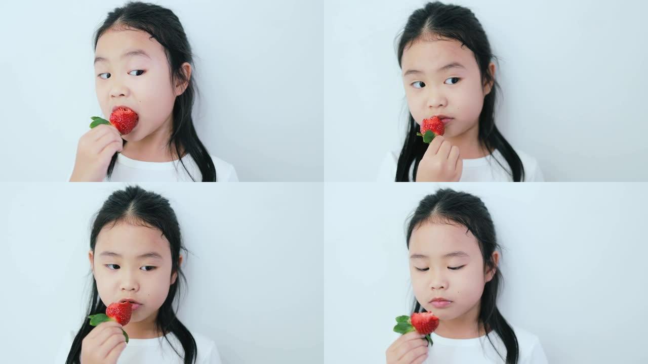 吃草莓的亚洲女孩。