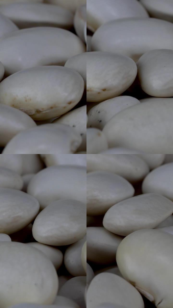 白色干有机芸豆在转盘上缓慢旋转，食物背景。
