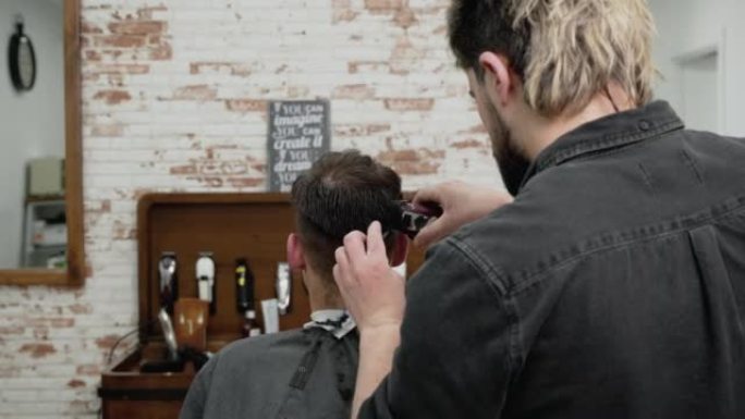 男人理发师在理发店用剪刀剪发男客户的头发。发型设计过程。高质量4k镜头