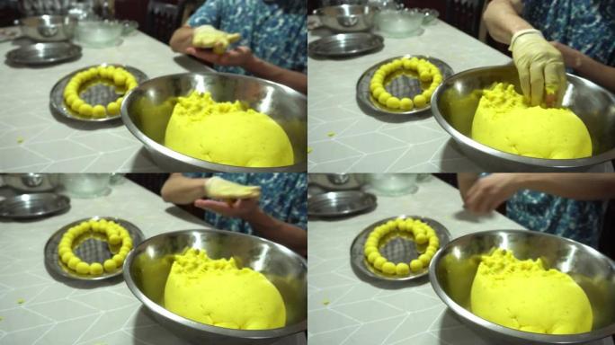 一个男人用手在桌子上的金属容器上制作Causa de Lima小球的特写镜头，典型的4k秘鲁食物