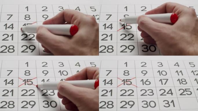 人的手用红笔在纸质日历上写下第23天。