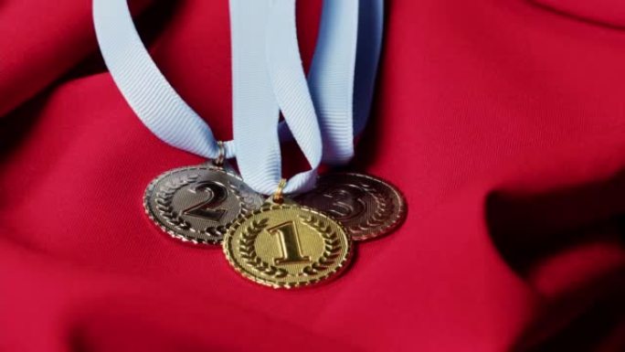 金、银、铜牌，红底彩带特写。第一、第二和第三名。获奖和胜利，赢得冠军。