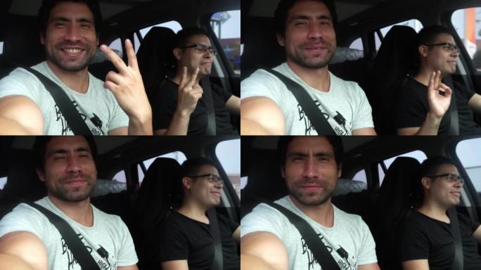 在4k白天，两个白人朋友在路上开车旅行的自拍，看着相机，用手笑着打手势