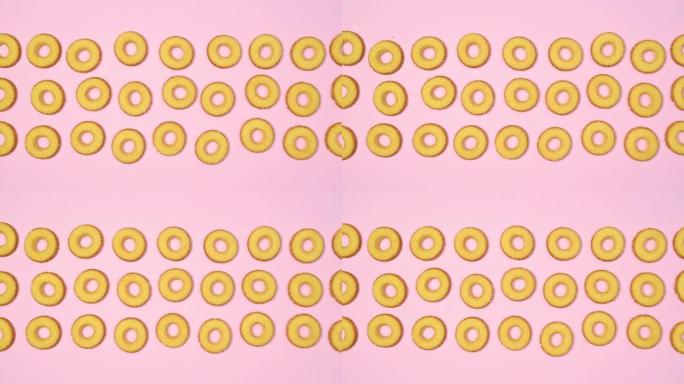 圆形饼干饼干以柔和的粉红色主题分为三列。停止运动平铺