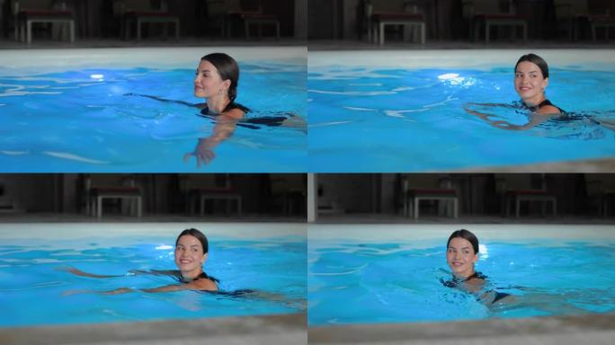 穿着时尚比基尼的迷人女人在酒店游泳池游泳