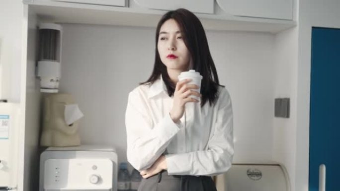 办公室休息时，年轻女员工用咖啡机煮咖啡的肖像。
