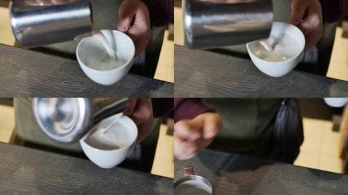 咖啡师将泡沫牛奶倒入卡布奇诺杯中。特写，慢动作