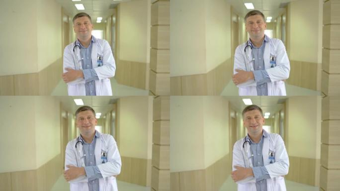 微笑快乐快乐的男性医生医务人员的肖像穿着白色长袍，脖子上戴着听诊器站在现代医院诊所，双臂交叉看着相机