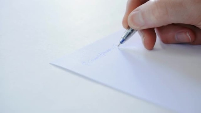 一只手紧紧在白纸上写一封信