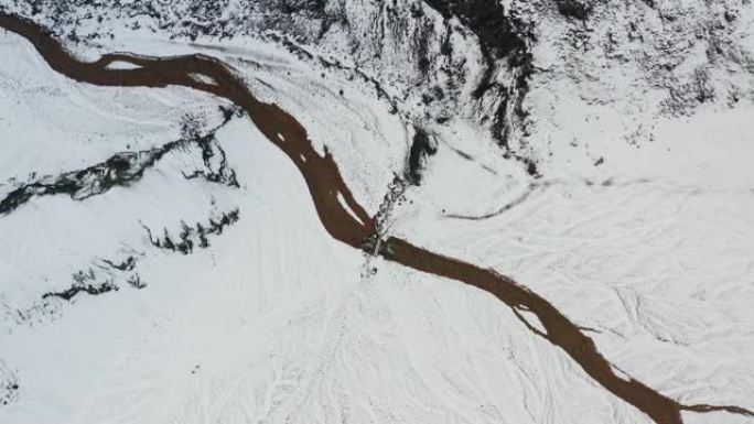 无人机覆盖着冰雪覆盖的景观，冰冻的编织河床