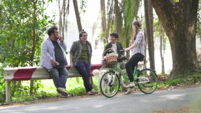 女人骑自行车回家时停下来问候她的朋友。