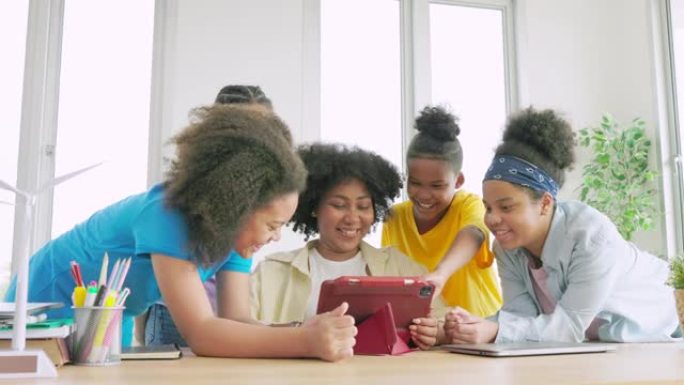 非裔美国老师在平板电脑上向学生展示清洁能源教材