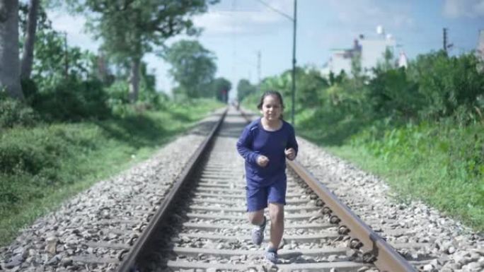 印度孩子在印度喜马拉雅山脉的铁轨上奔跑，背景是绿色植物。体能训练