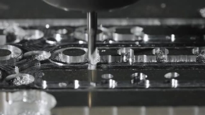 金属加工铣床。钻钢，慢动作。钻孔机加工金属，切出形状。现代细节加工技术。关闭工业细节