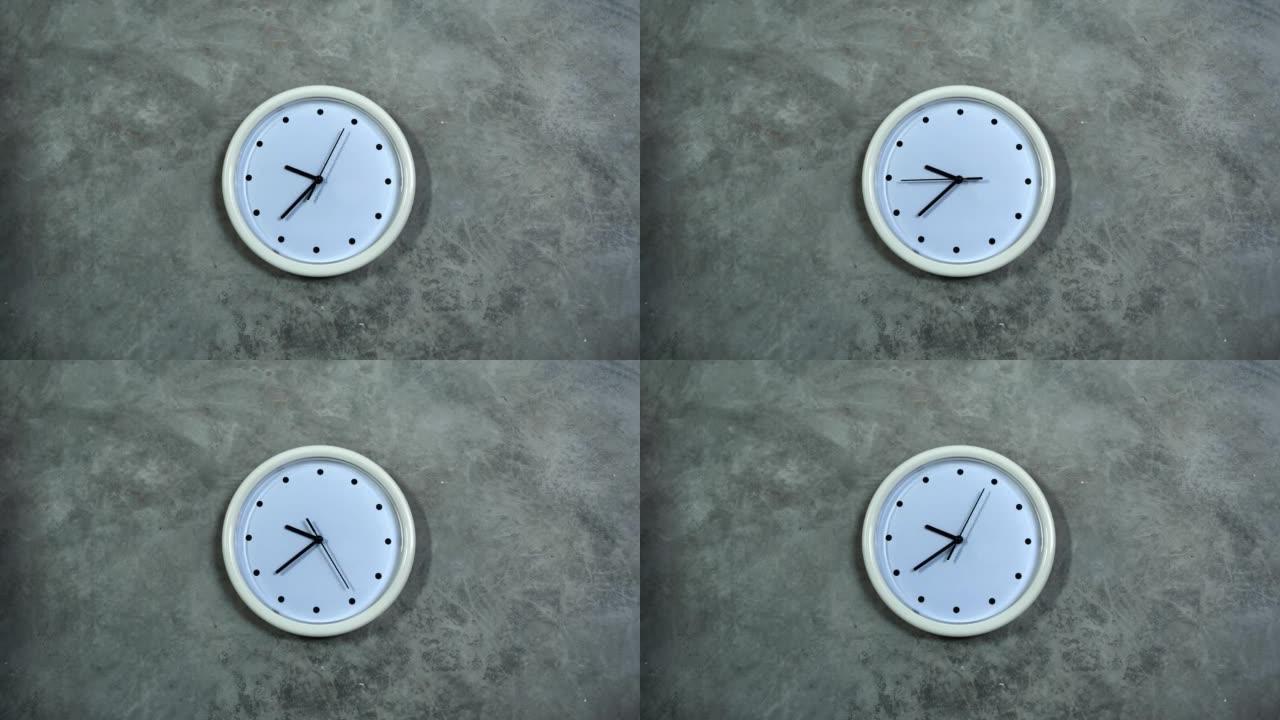 白色的办公室时钟挂在灰色的混凝土墙上。时间流逝，时间流逝