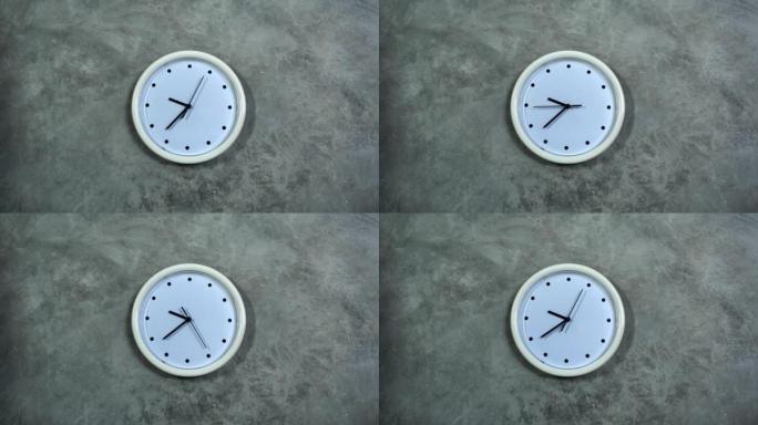 白色的办公室时钟挂在灰色的混凝土墙上。时间流逝，时间流逝