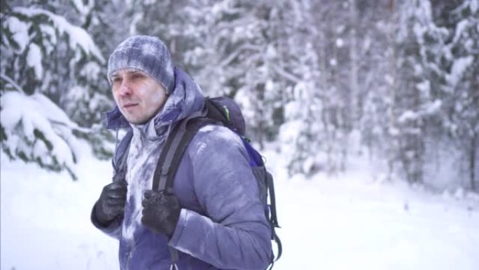 寒冷冬天的斯特恩冻人背着背包穿越冬季森林