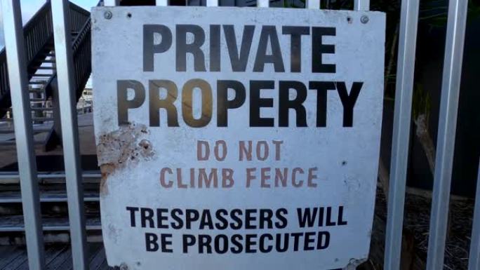 栅栏上的私人财产警告标志。不要爬。侵入者将被起诉。